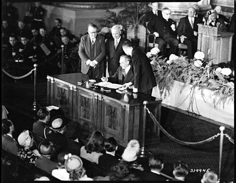 Yhdysvaltain ulkoministeri Dean Acheson allekirjoitti Pohjois-Atlantin sopimuksen 4. huhtikuuta 1949, seurassaan presidentti Harry Truman ja varapresidentti Alben Barkley.
