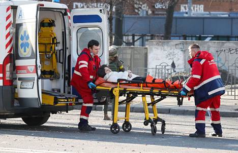 Tulituksessa haavoittunutta naista vietiin ambulanssiin lauantaina aamulla Kiovassa.