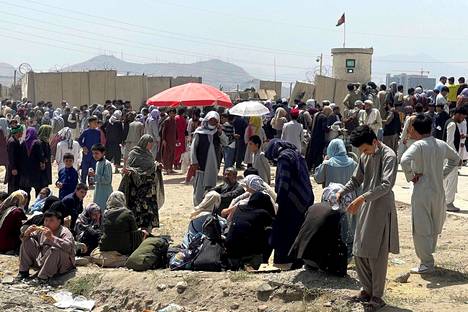 Ihmisiä odottamassa lentokentän liepeillä Kabulissa tiistaina.