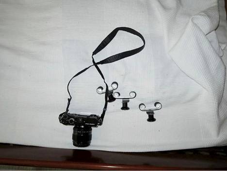 Kamera ja kellojen pidikkeitä, jotka olivat uhrin sängyn jalkopäässä.