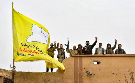 SDF-joukot tuulettivat nostettuaan keltaisen lippunsa rakennuksen katolle Baghuzissa sunnuntaina.