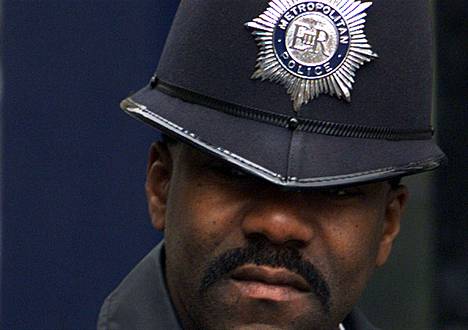 Poliisien kypäröissä on kuningattaren tunnukset. 