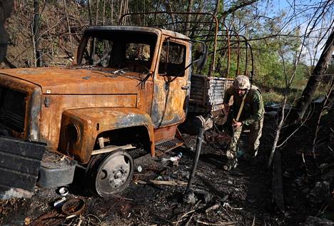 Ukrainalainen sotilas kävelee poltetun ajoneuvon ohi rintamalla Donetskin alueella 23. syyskuuta 2022.
