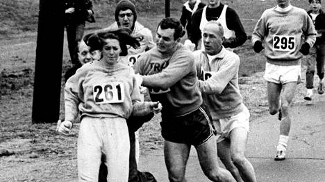 Kathrine Switzer joutui kilpailunjohtajan (takana vasemmalla) sabotaasiyrityksen kohteeksi Bostonin maratonilla 1967. Kilpakumppanit päättivät kuitenkin suojella Switzeriä ja työnsivät kilpailunjohtajan ulos radalta.