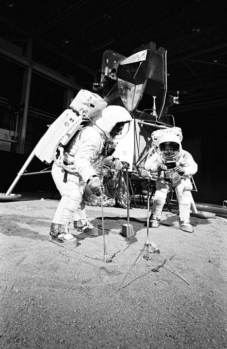 Apollo 11 -miehistö harjoitteli Kuun pinnalla tarvittavien työvälineiden käyttöä huhtikuussa 1969. Kuumoduulin lentäjä Buzz Aldrin (vas.) poimii näytteitä, ja komentaja Neil Armstrong pitelee näytepussia. Taustalla seisoo kuumoduulin malli.