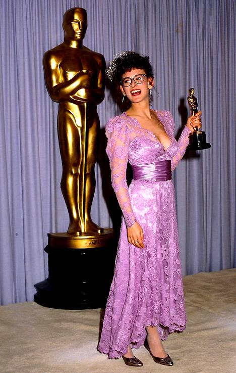 Marlee Matlin kiteytti jotain 1980-luvun muodista tähän liilaan pitsiunelmaan voittaessaan vuonna 1987 ensimmäisenä kuurona näyttelijänä Oscarin. Matlin oli tuolloin vain 21-vuotias, ja hän on yhä kaikkein nuorimpana parhaasta naispääosasta palkittu näyttelijä.