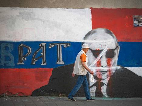 Mies käveli Belgradissa Vladimir Putinista maalatun graffitin ohi. 