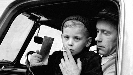 Alkuperäisen kuvatekstin mukaan tämä kuva on vuodelta 1958 osa kolmen kuvan sarjaa, jossa ”taksi oli kuljettamassa raajarikkoisia.” Kuvissa näkyy, että pieni poika ei itse polta tupakkaa, mutta aikuinen mies laittoi tupakan lapsen huulien väliin kuvaa varten.