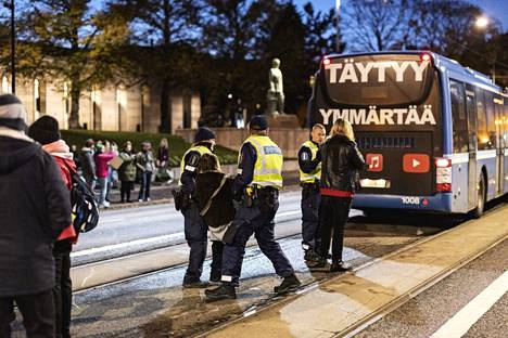 Poliisi joutui kantamaan osan kiinniottamistaan mielenosoittajista bussiin.
