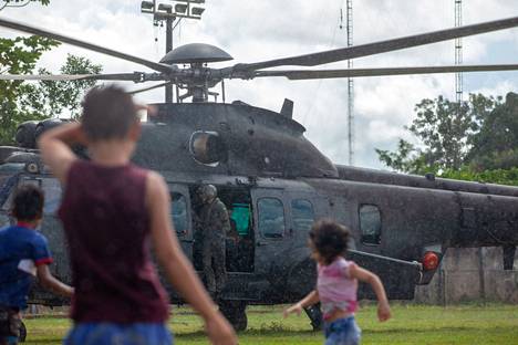 Lapset leikkivät Brasilian armeijan helikopterin vieressä, joka osallistuu kadonneen tutkija Bruno Pereiran ja toimittaja Dom Phillipsin etsimiseen.