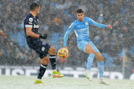 Manchester Cityn Joao Cancelo torjumassa West Hamin hyökkäystä talvisissa olosuhteissa.