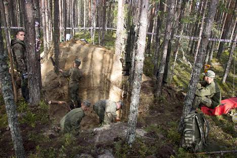 Venäläiset sotilaat auttoivat etsintäryhmää kaivamaan Sandarmohin hiekkamaastoa.