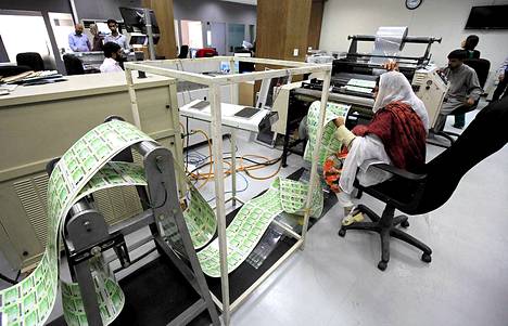 Pakistanin väestörekisterin eli NADRA:n työntekijä tarkastelee vastaprintattuja henkilökortteja NADRAN pääkonttorissa Islamabadissa.