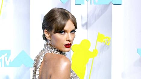 Taylor Swift asteli punaiselle matolle näyttävässä asussa.