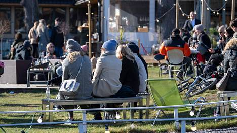 Tukholmalaiset nauttivat sunnuntaina Djurgårdenin terasseilla kylmästä mutta aurinkoisesta säästä.