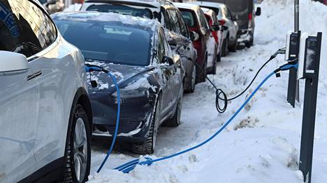 Sähköautoja latauksessa kylmänä pakkaspäivänä Runeberginkadulla Helsingissä 15. tammikuuta 2021. Vielä tällä vuosikymmenen alkupuolella ladattavat hybridit ovat autoalan ennusteen mukaan täyssähköautoja suositumpia, mutta täyssähköautojen suosio kasvaa erityisesti vuoden 2025 jälkeen.