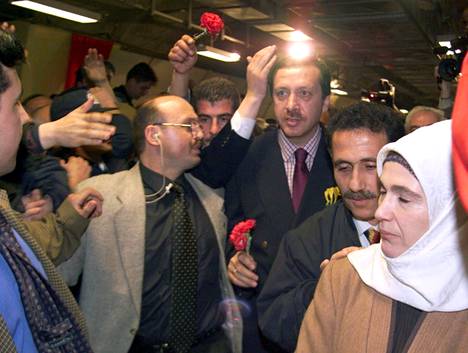 Recep Tayyip Erdogan yhdessä vaimonsa Eminen (oik.) ja kannattajiensa kanssa maaliskuussa 1999 päivää ennen kuin Erdogan lähti istumaan neljän kuukauden vankeustuomiotaan.