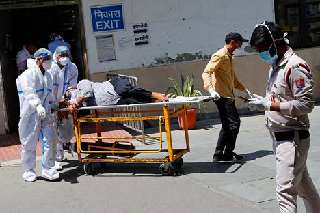 Koronapotilasta siirrettiin sairaalan ulkopuolella Delhissä lauantaina.