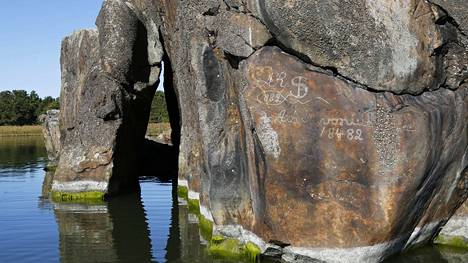 Kiven kyljessä on yli sata vuotta vanhoja kaiverruksia.