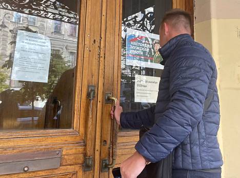В Петербурге молодые мужчины стабильно приходят в военкоматы. На двери военкомата на улице Чайковского  война рекламируется как «настоящая мужская работа».