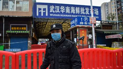Poliisi vartioi suljettua Huananin tuoretoria Wuhanin kaupungissa Kiinassa 24. tammikuuta 2020. Huananin toria on pidetty todennäköisenä pandemian alkupisteenä, jossa koronavirus olisi tarttunut eläimestä ihmiseen.