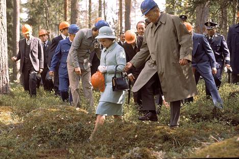 Englannin kuningatar Elisabet raahattiin myös metsätyömaalle. Oranssia kypärää hän ei suostunut päähänsä laittamaan.