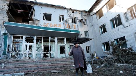 Nainen seisoo tuhoutuneen paikallisen sairaalan ulkopuolella Volnovahassa.