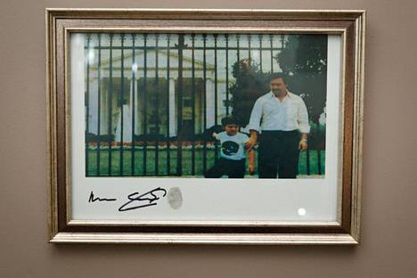 Kuuluisa kuva Pablo Escobarista ja hänen pojastaan Juan Pablosta Valkoisen talon edustalla. Kuva on kopio alkuperäisestä. Nimikirjoitus on Escobarin veljen, Roberton.