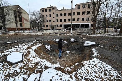Mies seisoo pommituksen jäljiltä syntyneessä kuopassa ukrainalaisen sotilasrakennuksen edustalla Kiovan lähistöllä Brovaryssa.