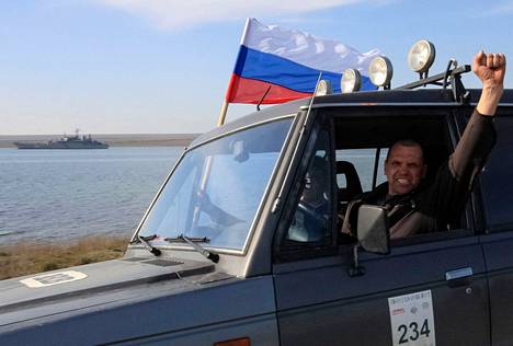 Venäjämielisten ”itsepuolustusjoukkojen” jäsen kohotti nyrkkinsä ilmaan autoillessaan Ukrainan laivaston maihinnousualuksen ohi Krimin niemimaalla maaliskuussa 2014. Samoihin aikoihin ukrainalaiset vetäytyivät Krimiltä ja Venäjä sai sen haltuunsa.