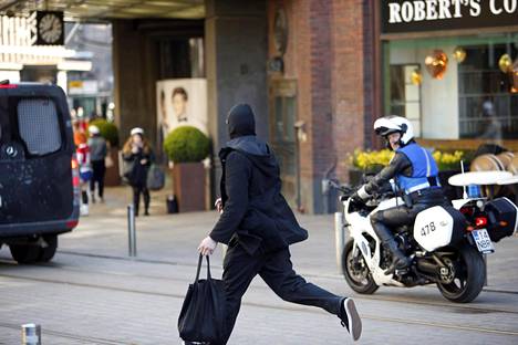 Anarkistien vappumarssille osallistunut henkilö juoksi kohti poliisin moottoripyörää.