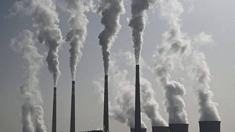 Ympäristötoimista aiheutuvat inflaatiopaine voi olla aiemmin arvioitua laajempaa. Kuvassa voimalaitoksen savupiippuja Kiinan Zhangjiakoussa, joka on yksi ensi talven olympialaisten pitopaikoista.