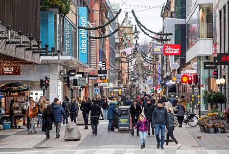 Ihmisiä Tukholman keskustassa. Tukholmassa on kehotettu ihmisiä välttämään sisätiloja kuten kauppoja.