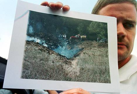 Mark Stahl näyttää ottamaansa kuvaa. Stahl kuuli, kun lentokone iskeytyi maahan ja meni törmäyspaikalle, jossa hän otti käsissään pitelemänsä kuvan.