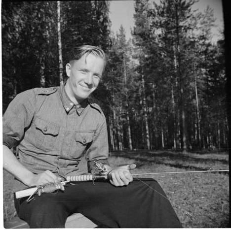 Luutnantti Håkan Strömberg kuvattuna Kontupohjassa kesäkuussa 1942. Alkuperäisen kuvatekstin mukaan hän on Hirvaksen lentotukikohdassa kunnostamassa kalastusvehkeitään, ja takana hänellä on tuolloin juuri 101 sotalentoa.