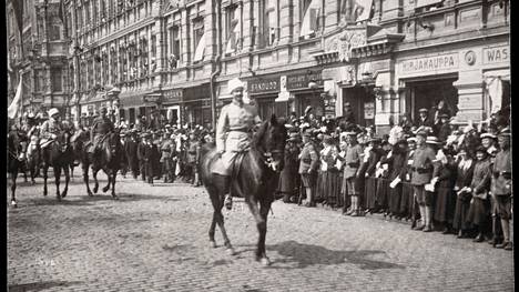 Valkoinen kenraali Mannerheim voitonparaatissa Helsingissä vuonna 1918. Haminassa järjestettävä näyttely esittelee yhä kiistellyn sodan aineistoa.