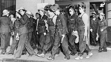Hitsaajan työtä tekevät naiset matkalla töihin vuonna 1943. Työvaatteinaan he käyttivät farkkuja.