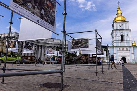 Ihmiset katsomassa tuhoutuneita venäläisiä sotilasajoneuvoja esittelevää näyttelyä lähellä Kiova is The Unbreakable Heart of Europe -valokuvanäyttelyä Pyhän Mikaelin aukiolla Kiovassa Ukrainassa 25.5.2023.