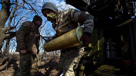 Ukrainalaissotilaat kantavat telakanuunan ammusta lähellä Bahmutia. Ukraina kaipaa kipeästi lisää ammuksia.
