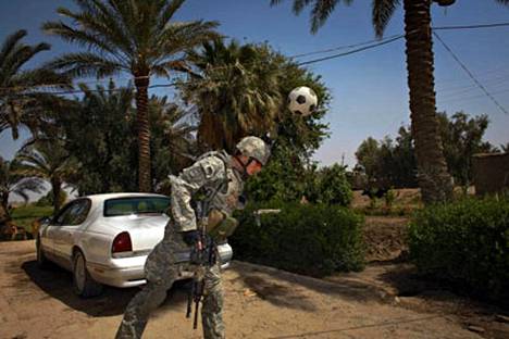 VUODEN LEHTIKUVA: Ylikersantti Matt Merced pelaa sheikki Munderin lasten kanssa jalkapalloa Bagdadin provinssissa.