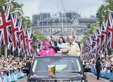 Kansa saapui tervehtimään kuningatar Elisabetia tämän 90-vuotispäivänä. Mukana olivat vilkuttamassa olivat prinssi William, herttuatar Catherine, prinssi Harry ja prinssi Philip. 