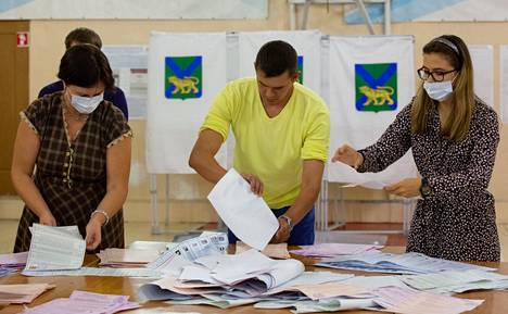 Paikallisen vaalilautakunnan jäseniä tutkimassa äänestyslomakkeita vaalihuoneistojen sulkeuduttua Vladivostokissa.