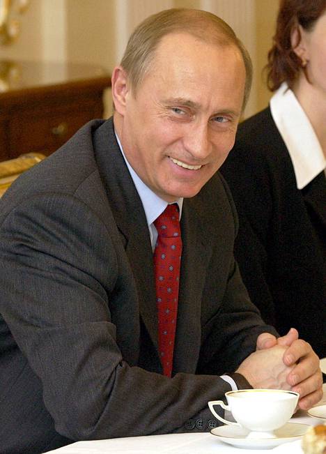 Vladimir Putin hymyilee puhuessaan kesäolympialaisten urheilijoille Novo-Ogaryovossa Moskovan ulkopuolella 10. maaliskuuta 2004.