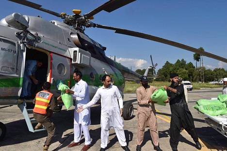 Hallituksen virkamiehet lastasivat helikopteriin avustusruokapusseja tulvasta kärsineille ihmisille Saidu Sharifissa tiistaina.