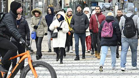 Pyöräilijä ja jalankulkijoita Helsingin Kauppatorilla vilpoisassa kevätsäässä 18. huhtikuuta.