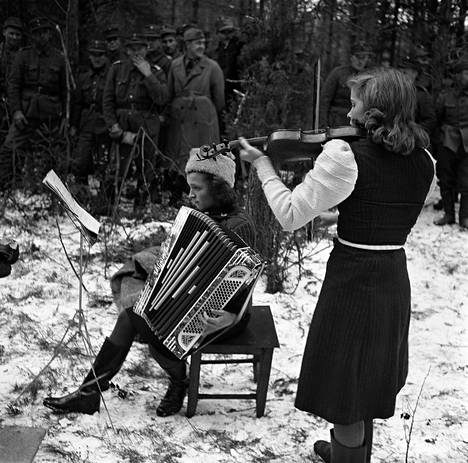 Viihdysjoukkojen työtä: Aapo Similän kiertueen tytöt soittamassa Kaarina-kappaletta Koskitsa-joella lokakuussa 1941.