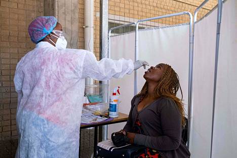 Terveydenhuollon työntekijä otti naiselta koronatestinäytteen Johannesburgissa tiistaina. 