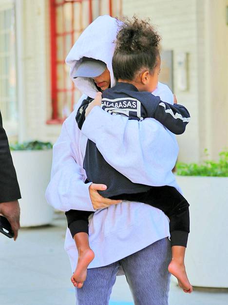 Kasvonsa peittänyt Kim Kardashian piti tiukasti sylissään esikoistytärtään, Northia, perheen poistuessa New Yorkin asunnoltaan.