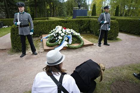 Ihmiset ottivat valokuvia presidentti Koiviston haudalla.