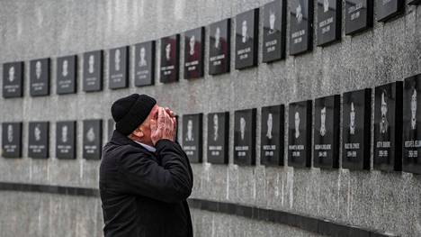 Kosovolaismies pyyhki kyyneleitään Racakin joukkomurhan uhrien muistomerkin edustalla tammikuussa 2020.